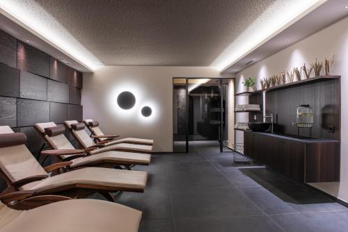 a salon with a row of chairs and a waiting room at Hotel Ladurner in Merano