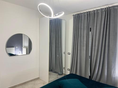 a bedroom with a mirror and a blue bed at La perla del mare in Fiumicino