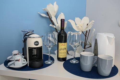 un tavolo con una bottiglia di vino e bicchieri di Porto Azzurro apartments a Tivat