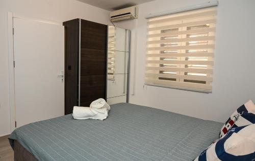 a bedroom with a bed with a towel on it at Porto Azzurro apartments in Tivat