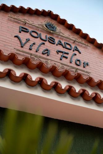 a sign on top of a roof on a building at Pousada Vila Flor in Rio das Flores