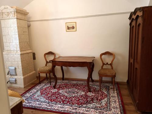 een kamer met een tafel en twee stoelen op een tapijt bij Rezidenca Sv. Peter in Malečnik