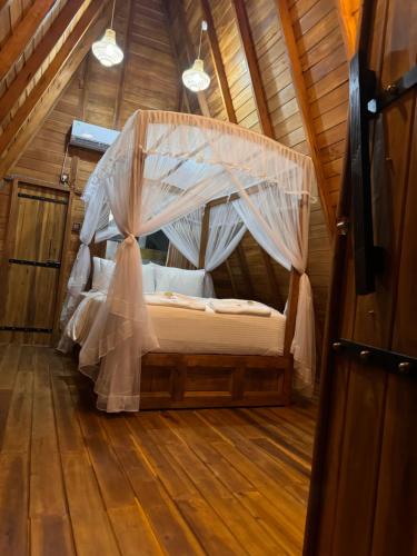 a bedroom with a canopy bed in a wooden room at Sundown Lake Hotel & Spa in Habarana