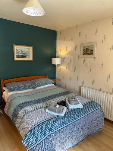 um quarto com uma cama grande com lençóis azuis e brancos em Marine Villa B&B em Annalong
