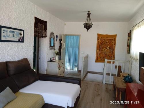 ein Wohnzimmer mit einem Bett und einem Sofa in der Unterkunft Casa Pachamama. Castell del Rey. Almería in Almería