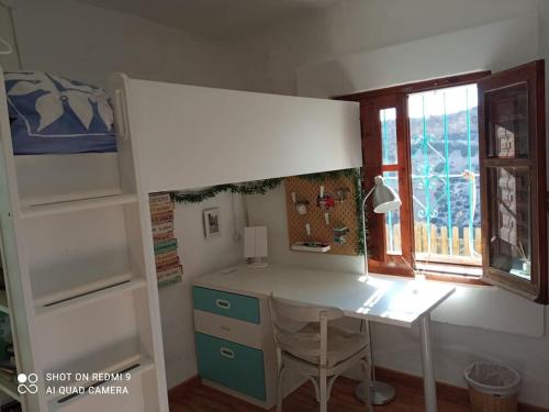einen Schreibtisch in einem Zimmer mit einem Bett und einem Fenster in der Unterkunft Casa Pachamama. Castell del Rey. Almería in Almería