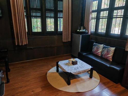 a living room with a couch and a coffee table at ธารทอง ลอดจ์ Tharnthong Lodge in Ban Pang Champi
