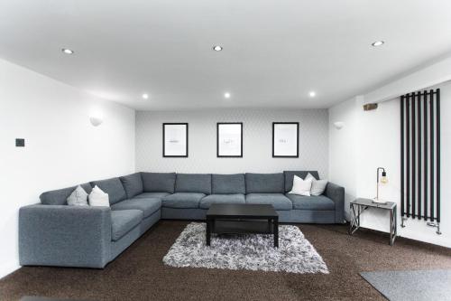 een woonkamer met een grijze bank en een tafel bij Garden Apartment - Close to Town Centre - sleeps 6 in Buxton