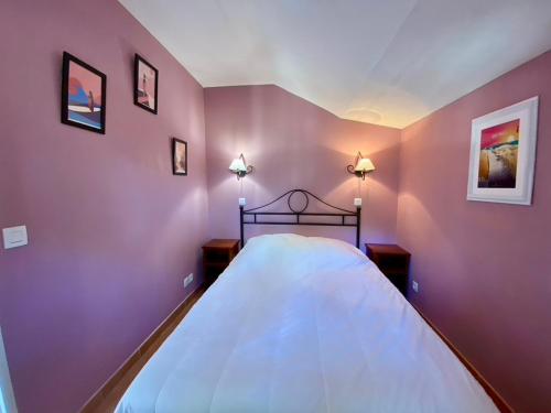 une chambre avec un grand lit aux murs violets dans l'établissement Appartement dans résidence avec piscine, à Lacanau-Océan