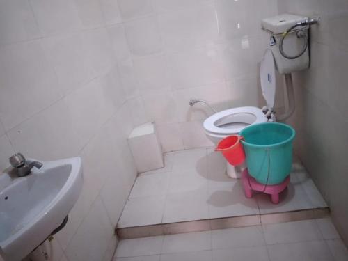 a small bathroom with a toilet and a sink at Hotel Gayatri Guest House Haridwar Near Railway Station - Ganga Ghat - Best Hotel in Haridwar in Haridwār