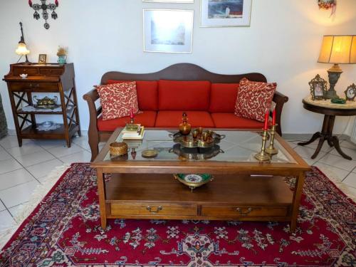 a living room with a red couch and a table at Efi's apartment in Apróvaton