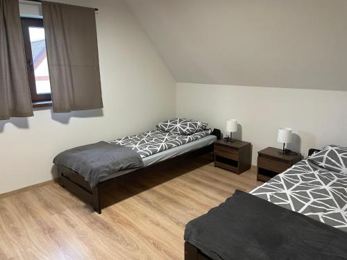 a bedroom with two beds and a window at Domki Mucharskie in Mucharz