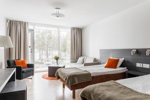 a hotel room with two beds and a couch at Kultaranta Resort in Naantali