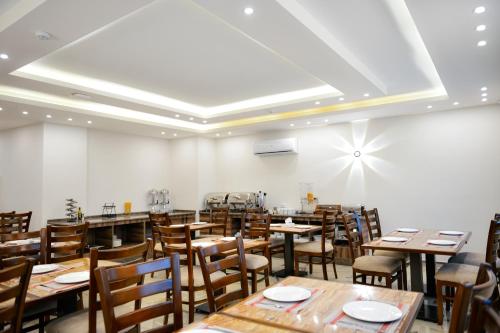 comedor con mesas y sillas de madera en Petra Premium Hotel en Wadi Musa