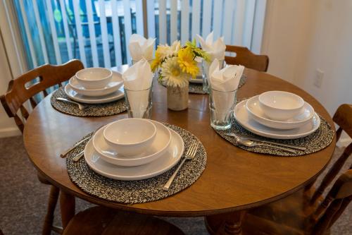 a wooden table with plates and napkins and flowers on it at Hendo Hideaway A 2bed/1bath in Hendersonville