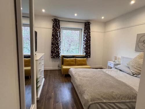 a bedroom with a bed and a couch and a window at 3 Bed luxury house, 10 min walk to underground in London