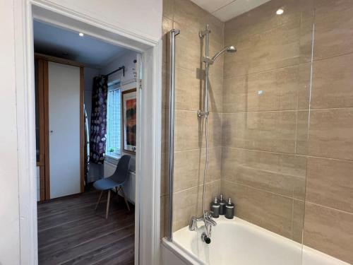 y baño con ducha y bañera. en 3 Bed luxury house, 10 min walk to underground en Londres