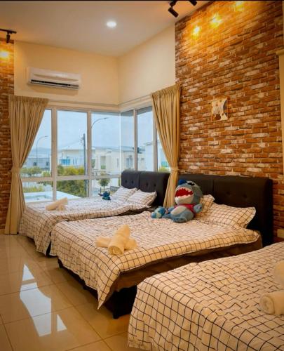 three beds in a room with a brick wall at 16pax+Ninja's SweetHome Seremban in Seremban