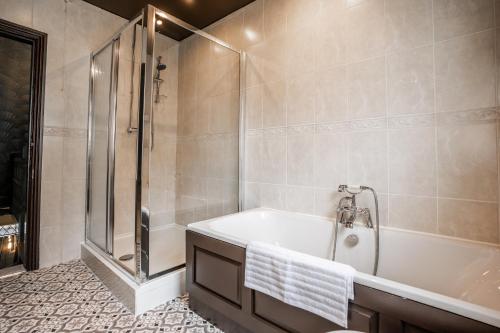 a bathroom with a bath tub and a shower at Arkles - Victorian Gem in Liverpool