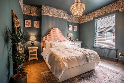 a bedroom with a bed with a red headboard at Arkles - Victorian Gem in Liverpool