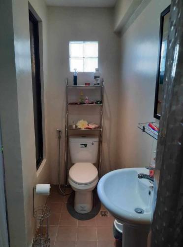 a bathroom with a white toilet and a sink at Casa G in Manila