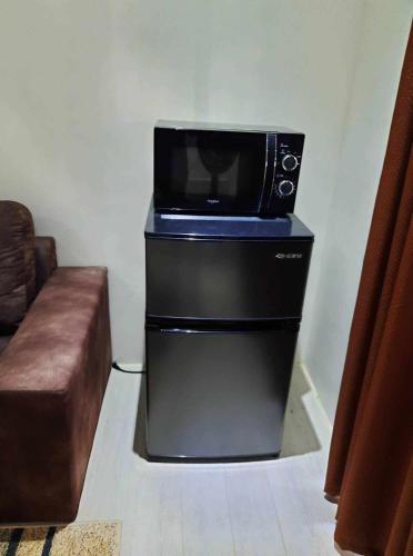 a microwave sitting on top of a refrigerator at Casa G in Manila