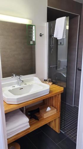 a bathroom with a sink and a shower at Grand Hôtel de la Poste in Saint-Jean-de-Luz