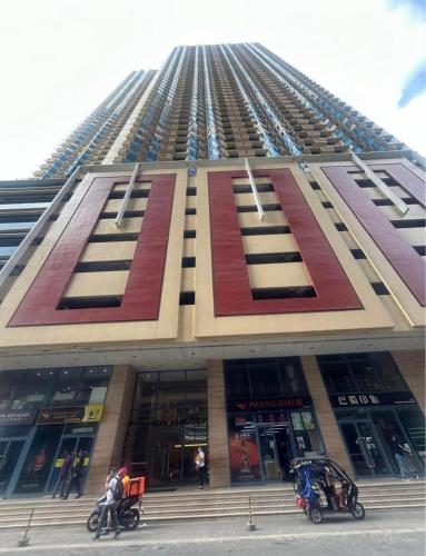 een hoog gebouw waar mensen voor staan bij Grand Riviera Suites in Manilla