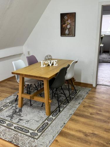 tavolo da pranzo con sedie bianche e tavolo in legno di Schelder Gästezimmer a Dillenburg