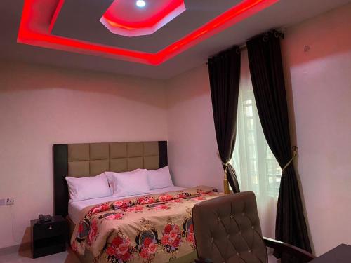 1 dormitorio con 1 cama con techo rojo en Diamond Castle Hotel, en Owerri