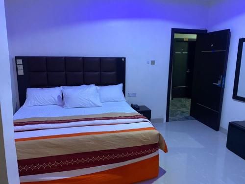 Schlafzimmer mit einem großen Bett mit einem schwarzen Kopfteil in der Unterkunft Diamond Castle Hotel in Owerri