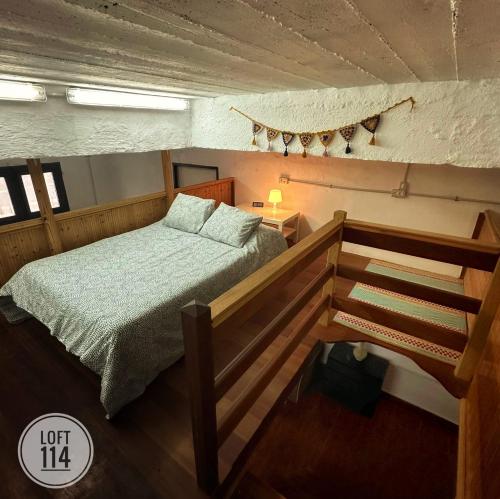 a small bedroom with a bed and a staircase at LOFT-114 in Santa Cruz de Tenerife
