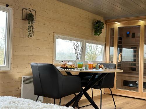 eine Küche mit einem Tisch und Stühlen im Zimmer in der Unterkunft La Cabane D'Emma Spa&Sauna privé in Bannalec