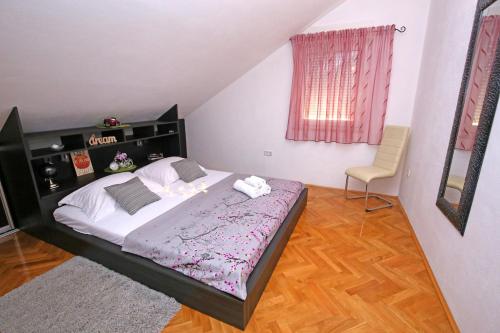 ein Schlafzimmer mit einem großen Bett und einem Stuhl in der Unterkunft Top apartment in Kaštela