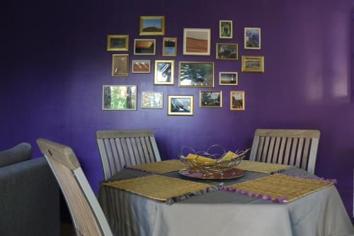 a dining room table with a purple wall at Studio charmant au calme in Aix-en-Provence