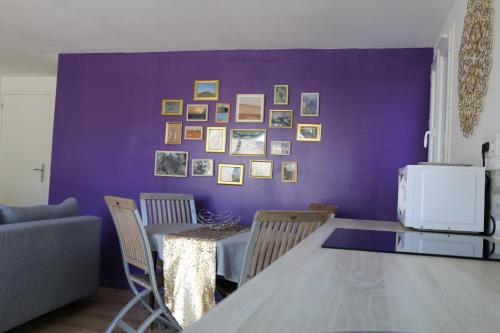 a dining room with a purple wall with a table and chairs at Studio charmant au calme in Aix-en-Provence