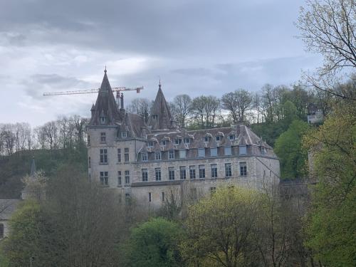 a large castle with a crane on top of it at Heerlijk vakantiehuis in bos bij Durbuy in Durbuy