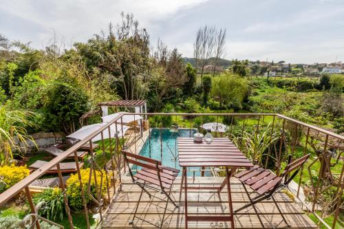 a balcony with a table and chairs and a pool at Casa da Benfeitoria in Guimarães