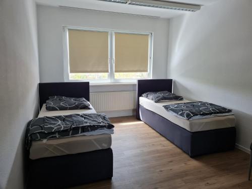 Duas camas num quarto com uma janela em Pension Calenius em Erfurt