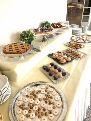 a table with many different types of pastries and pies at Hotel 90 in Capurso