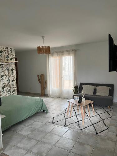 - un salon avec un lit et une table basse dans l'établissement Grand studio avec véranda et parking, à Auch