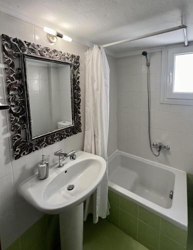 a bathroom with a sink and a bath tub with a mirror at City lux apartment 2 in Serres
