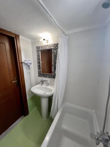 uma casa de banho branca com um lavatório e uma banheira em City lux apartment 2 em Serres