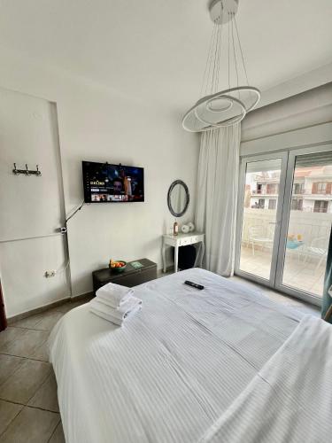 a bedroom with a large white bed and a window at City lux apartment 2 in Serres