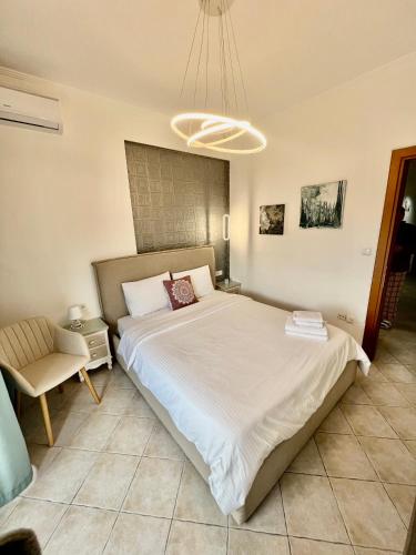 a bedroom with a large bed and a chair at City lux apartment 2 in Serres