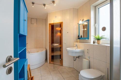 un bagno con vasca, WC e lavandino di Haus-Ostseeapartments-am-Fehmarnsund-Wohnung-27-Strandrubin a Grossenbrode