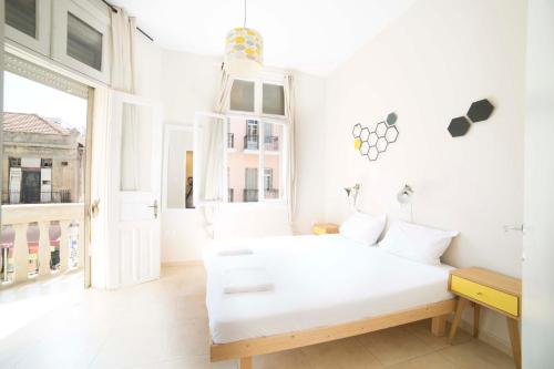 a white room with a white bed and a window at OurPlace Nachalat Binyamin in Tel Aviv