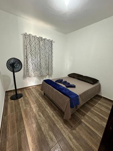 a bedroom with a bed and a fan at Casa Maresia in Saquarema