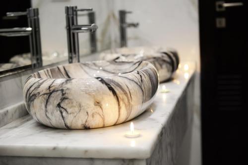 a group of three sinks with candles on a counter at Petra Premium Hotel in Wadi Musa