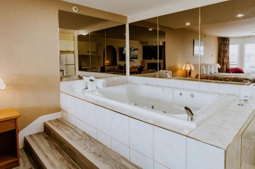 y baño con bañera grande y espejo grande. en Mosaic Suites, en Red Deer